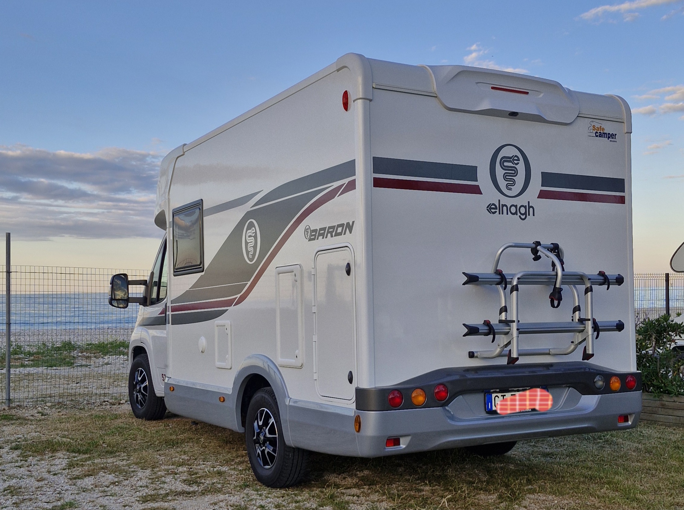 un camper parcheggiato in spiaggia al tramonto. I migliori consigli di viaggio e percorsi trekking